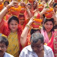 neu delhi, indien 03. april 2022 - frauen mit kalash auf dem kopf während des jagannath-tempels mangal kalash yatra, indische hindu-anhänger tragen irdene töpfe mit heiligem wasser mit einer kokosnuss darauf foto