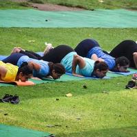 neu delhi, indien, 18. juni 2022 - gruppen-yoga-übungskurs für menschen unterschiedlichen alters im lodhi garden park. internationaler tag des yoga, große gruppe von erwachsenen, die draußen im park einen yogakurs besuchen foto