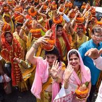 neu delhi, indien 03. april 2022 - frauen mit kalash auf dem kopf während des jagannath-tempels mangal kalash yatra, indische hindu-anhänger tragen irdene töpfe mit heiligem wasser mit einer kokosnuss darauf foto