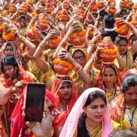 neu delhi, indien 03. april 2022 - frauen mit kalash auf dem kopf während des jagannath-tempels mangal kalash yatra, indische hindu-anhänger tragen irdene töpfe mit heiligem wasser mit einer kokosnuss darauf foto