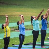 neu delhi, indien, 18. juni 2022 - gruppen-yoga-übungskurs für menschen unterschiedlichen alters im lodhi garden park. internationaler tag des yoga, große gruppe von erwachsenen, die draußen im park einen yogakurs besuchen foto