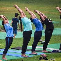 neu delhi, indien, 18. juni 2022 - gruppen-yoga-übungskurs für menschen unterschiedlichen alters im lodhi garden park. internationaler tag des yoga, große gruppe von erwachsenen, die draußen im park einen yogakurs besuchen foto