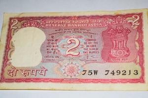 alte zwei rupie-scheine kombiniert auf dem tisch, indisches geld auf dem rotierenden tisch. alte indische Banknoten auf einem rotierenden Tisch, indische Währung auf dem Tisch foto