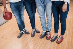 unteren Teil der Körper. Beschnittene Ansicht von Leuten im Bowlingclub, die bereit sind, Spaß zu haben foto