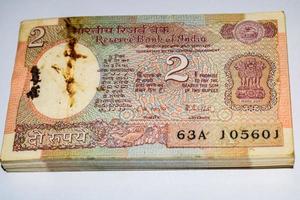 alte zwei rupie-scheine kombiniert auf dem tisch, indisches geld auf dem rotierenden tisch. alte indische Banknoten auf einem rotierenden Tisch, indische Währung auf dem Tisch foto