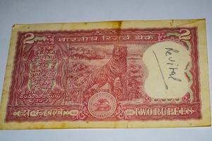 alte zwei rupie-scheine kombiniert auf dem tisch, indisches geld auf dem rotierenden tisch. alte indische Banknoten auf einem rotierenden Tisch, indische Währung auf dem Tisch foto