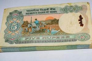 Alte Fünf-Rupien-Noten kombiniert auf dem Tisch, indisches Geld auf dem Drehtisch. alte indische Banknoten auf einem rotierenden Tisch, indische Währung auf dem Tisch foto