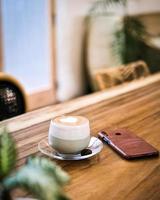 eine tasse heißen latte kaffee auf dem tisch zum frühstück foto