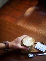 eine tasse heißen latte kaffee auf dem tisch zum frühstück foto
