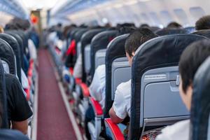 Sitze im Flugzeug und Passagiere sitzen im gesamten Bereich und warten darauf, dass das Flugzeug von der Landebahn abhebt. foto