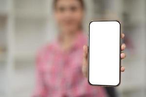 Modellbild einer schönen Frau, die ein Mobiltelefon mit leerem weißem Bildschirm hält und zeigt foto