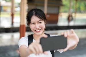 schönes asiatisches Mädchen, das bloggt, Foto mit Smartphone-Kamera macht, Momente festhält, Mädchen, das allein reist, Influencer, Sommerferien, Reise