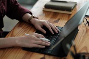 Schließen Sie herauf die Hand der Geschäftsfrau, die Tastatur schreibt. arbeiten von zu hause aus, fernarbeit, selbstisolierung, soziale distanzierung, quarantäne zur prävention von koronaviren. foto