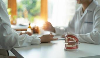zahnarzt- und patientendiskussion über geplante zahnbehandlung in der zahnklinik - zahnarztberatungskonzept foto