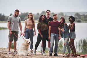 alle stehen. Die Leute feiern draußen. Multiethnische Freunde treffen sich am Wochenende foto