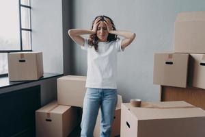 Erschöpfte Frau ist es leid, Kartons mit Klebeband zu verpacken. Angst und Stress. foto