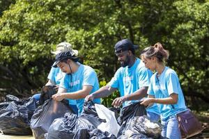 team von jungen und vielfältigen freiwilligen arbeitergruppen genießen karitative sozialarbeit im freien bei der reinigung von müll und abfalltrennungsprojekt im mangrovenwald foto