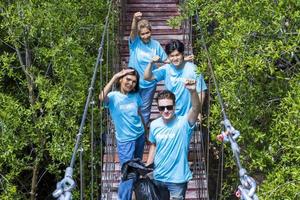 ein team von jungen und vielfältigen freiwilligen arbeitergruppen genießt die karitative sozialarbeit im freien bei der reinigung des müllprojekts im mangrovenwald foto