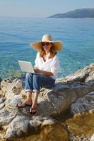 Frau mit Laptop am Meer