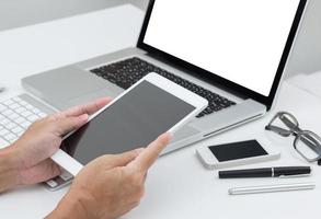 Mannhände, die Tablette mit Laptop-Computerhintergrund halten foto