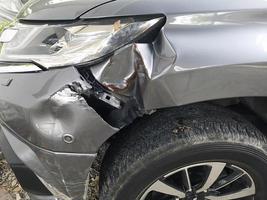 Die Front des Autos wird durch einen Unfall auf der Straße beschädigt foto