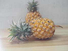 Ananas auf Holztisch, gelbe süße Frucht foto