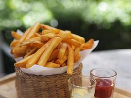 Pommes Frites, Kartoffelchips gelbe knusprige Pommes im Holzkorb, leckerer Snack foto