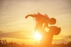 Vater brachte das Baby dazu, bei Sonnenuntergang laufen zu lernen. foto