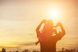 Vater brachte das Baby dazu, bei Sonnenuntergang laufen zu lernen. foto