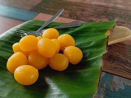 Thong Yod oder runde Eigelb-Torte, ein altes thailändisches Dessert, Orange und Gold, hat einen süßen Geschmack auf Bananenblättern foto