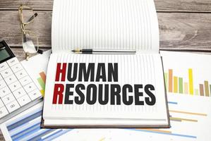 Text Human Resources auf braunem Tagebuch mit Taschenrechner, Brille auf Holzhintergrund foto