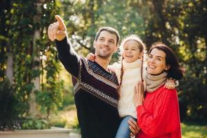 horizontales porträt der liebevollen familie verbringen freizeit zusammen, genießen ruhige atmosphäre. liebevolle Eltern spielen mit ihrem kleinen Kind, verbringen das Wochenende im Freien. Beziehungskonzept. foto