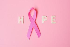 oktober brustkrebsbewusstseinsmonat, rosa band mit hoffnungstext auf rosa hintergrund zur unterstützung lebender und kranker menschen. internationales frauen-, mutter- und weltkrebstagskonzept foto