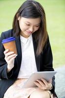 junge weibliche asiatische Geschäftsführerin mit Tablette