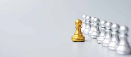 Goldene Schachfiguren oder Führergeschäftsmann heben sich von der Menge der silbernen Männer ab. Führungs-, Geschäfts-, Team-, Teamarbeits- und Personalmanagementkonzept foto