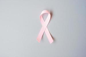oktober brustkrebsbewusstseinsmonat, rosa band auf grauem hintergrund zur unterstützung lebender und kranker menschen. internationales frauen-, mutter- und weltkrebstagskonzept foto