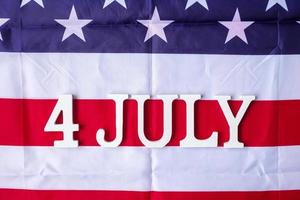 4. juli text auf dem hintergrund der flagge der vereinigten staaten von amerika. usa feiertag der unabhängigkeit und feierkonzepte foto