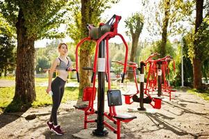 junges Mädchen hat das Training und macht Übungen im Freien auf Straßensimulatoren. sport, fitness, straßentrainingskonzept. foto