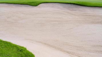 ästhetischer hintergrund des golfplatz-sandgrubenbunkers, der als hindernis für golfwettbewerbe wegen der schwierigkeit und wegen der schönheit vom platz herunterfällt. foto