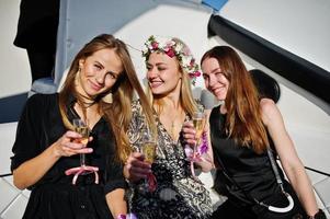 Mädchen trinken Champagner auf der Yacht auf dem Junggesellinnenabschied. foto