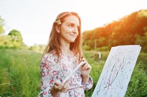 Porträt einer attraktiven jungen Frau in langer Kleidermalerei mit Aquarell in der Natur. foto