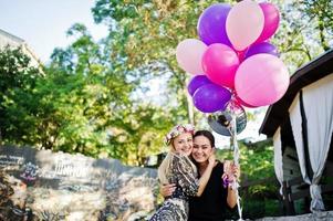 Zwei Mädchen tragen beim Junggesellinnenabschied Schwarz mit Luftballons. foto