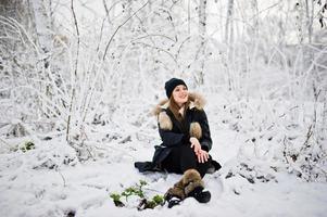 schönes brünettes Mädchen in warmer Winterkleidung. Modell auf Winterjacke und schwarzem Hut. foto