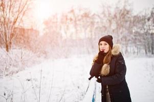 schönes brünettes Mädchen in warmer Winterkleidung. Modell auf Winterjacke und schwarzem Hut. foto