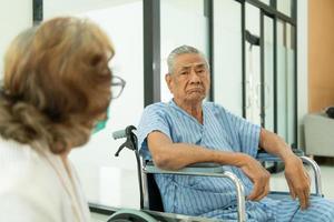 Ein älteres Ehepaar unterhielt sich und sah sich liebevoll und fürsorglich an. der mann war krank und behandelte den fuß mehrere tage im krankenhaus. foto