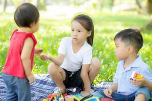 kleine Jungen und Mädchen spielen mit Spielzeugklötzen um Ideen und Inspirationen, Kinder lernen mit Bauklötzen für Bildung, Kinderaktivitäten und Spiele im Park mit Freude im Sommer. foto