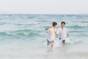 homosexuelles porträt junges asiatisches paar, das im sommer fröhlich zusammen am strand läuft, asien homosexueller tourismus für die freizeit und entspannen sie sich mit glück im urlaub auf meer, lgbt-rechtskonzept. foto