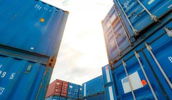 blauer und roter logistikcontainer gegen weißen himmel. Fracht- und Speditionsgeschäft. Containerschiff für die Import- und Exportlogistik. Logistikbranche. Container für LKW-Transport und Luftlogistik.