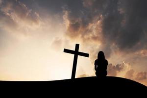 das kreuz und die frauen auf bergsonnenunterganghintergrund foto