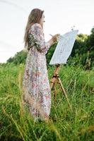 Porträt einer attraktiven jungen Frau in langer Kleidermalerei mit Aquarell in der Natur. foto